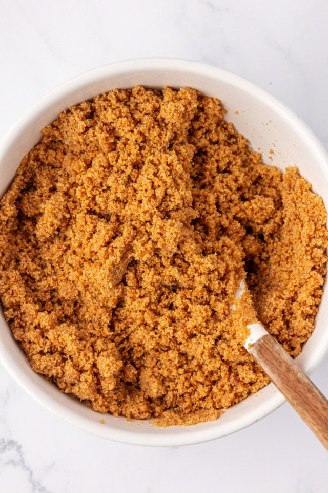 overhead view of graham cracker crust mixture in a mixing bowl