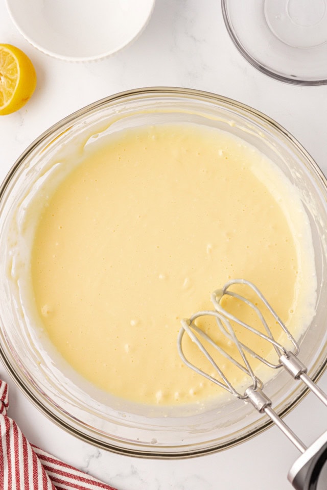 overhead view of cheesecake batter in a glass mixing bowl