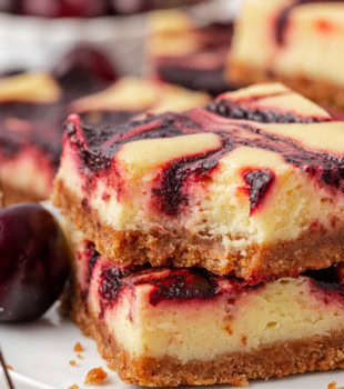 stack of two cherry cheesecake bars with a bite missing from the top bar