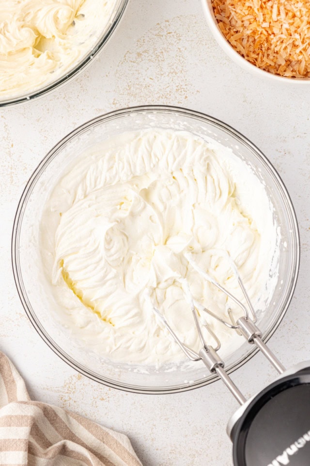 overhead view of whipped cream in a glass mixing bowl