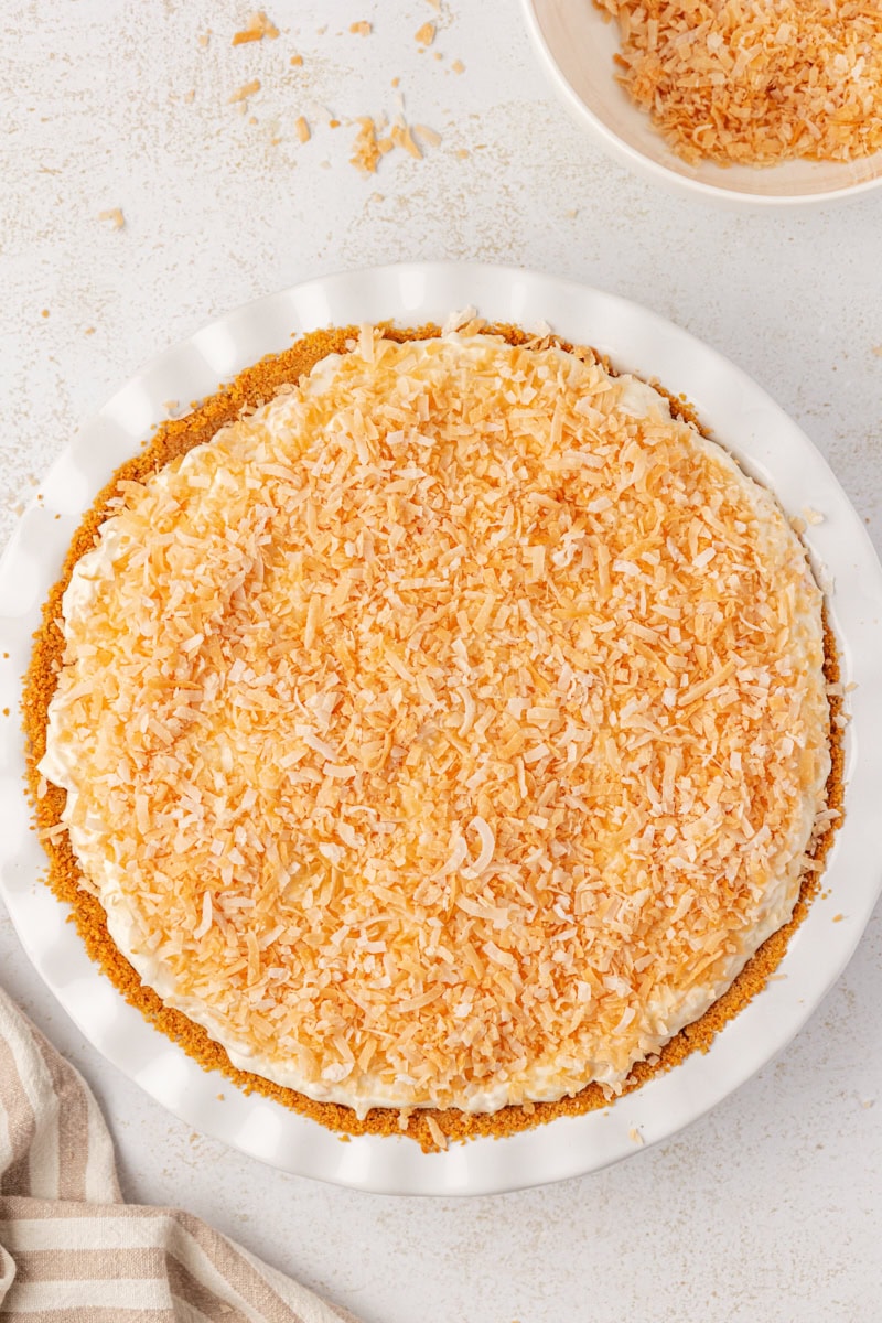 overhead view of no-bake coconut cheesecake topped with toasted coconut