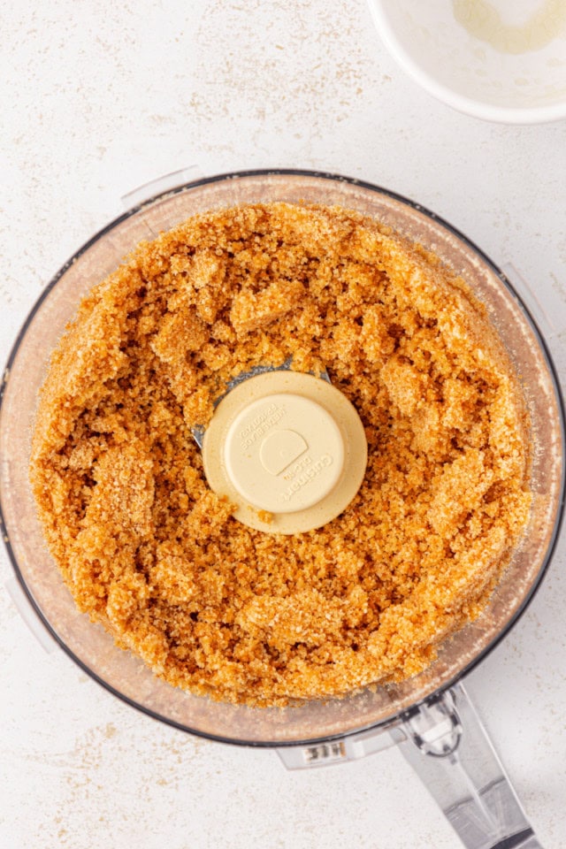 overhead view of vanilla cookie crust ingredients in the bowl of a food processor