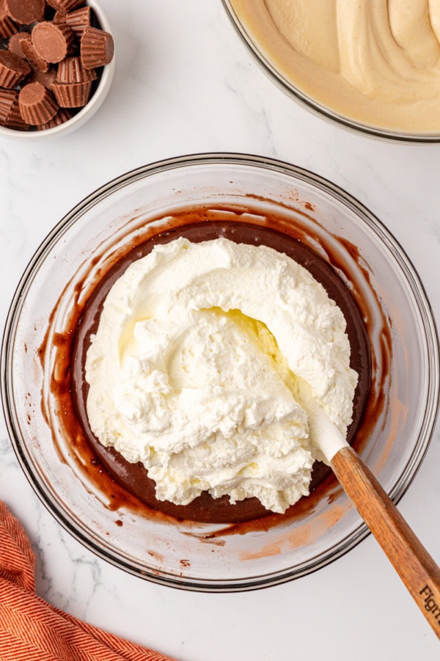 overhead view of whipped cream added to chocolate ice cream base