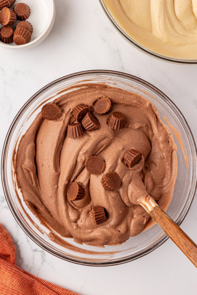 overhead view of mini peanut butter cups added to chocolate ice cream