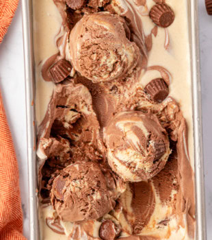 overhead view of no-churn chocolate peanut butter ice cream in a metal loaf pan with three scoops of ice cream on top