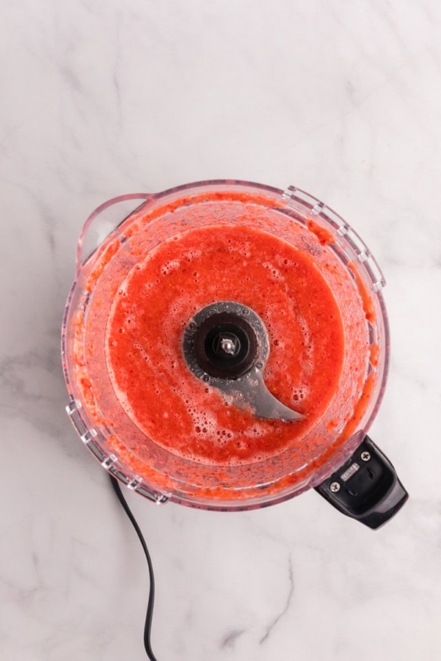 overhead view of blended strawberry puree in the bowl of a food processor