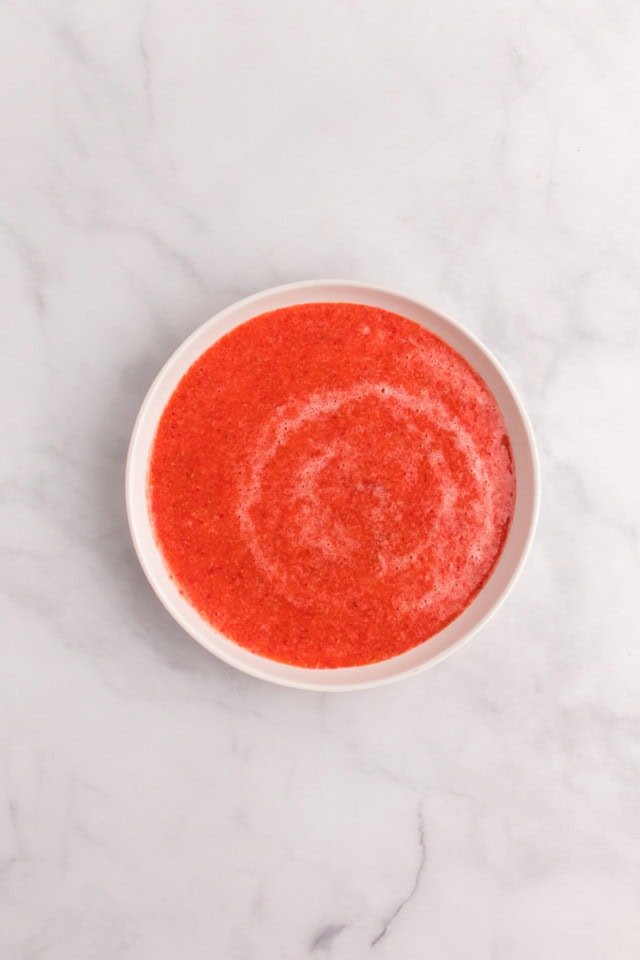 overhead view of strawberry puree in a white bowl