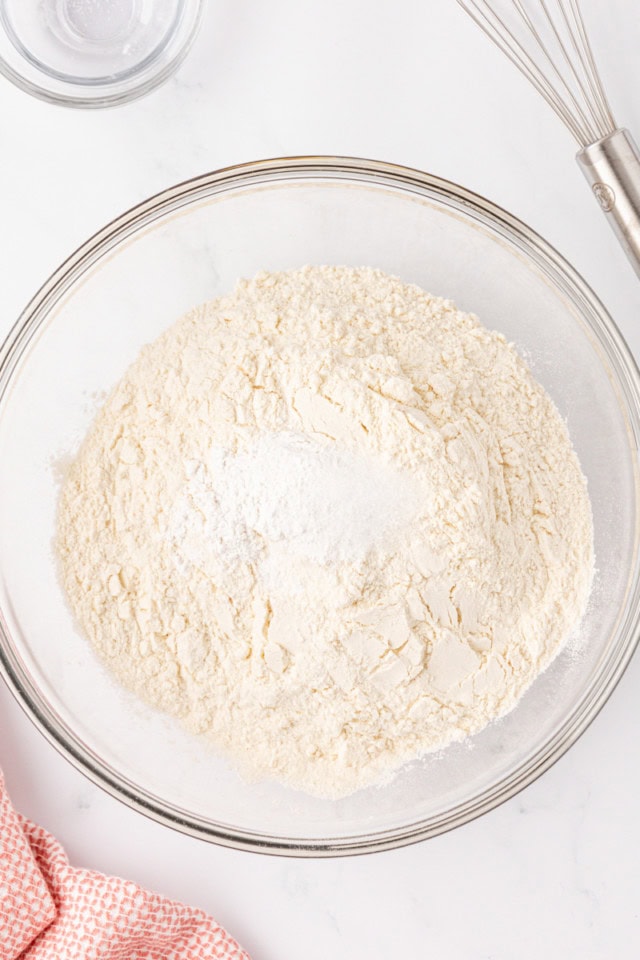 overhead view of flour, baking powder, and salt in a glass mixing bowl