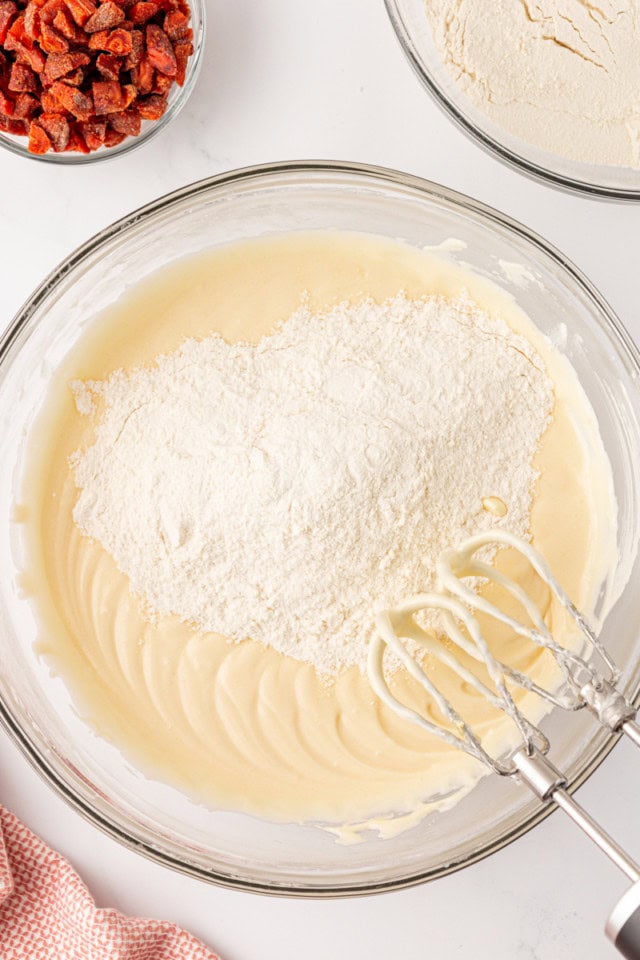 overhead view of dry ingredients added to wet ingredients for cream cheese cookie dough