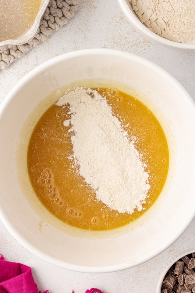 overhead view of dry ingredients added to wet ingredients for white chocolate brownies