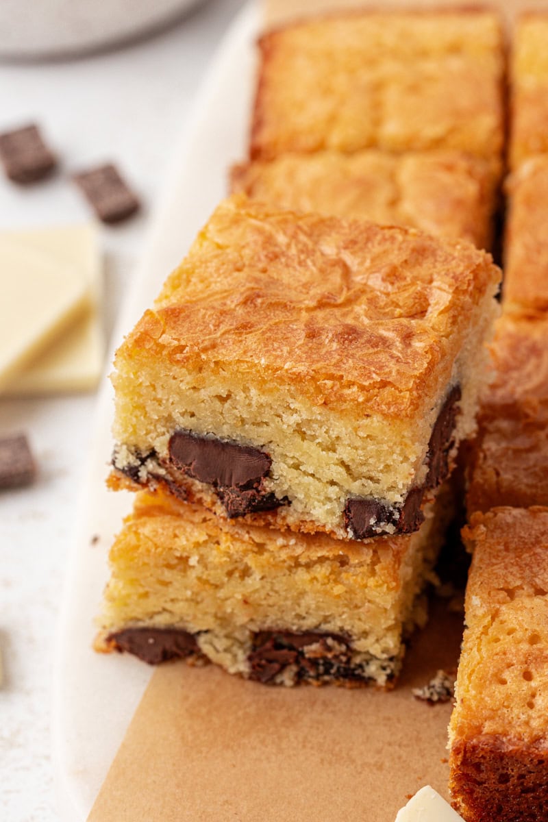 a stack of two white chocolate brownies alongside more brownies