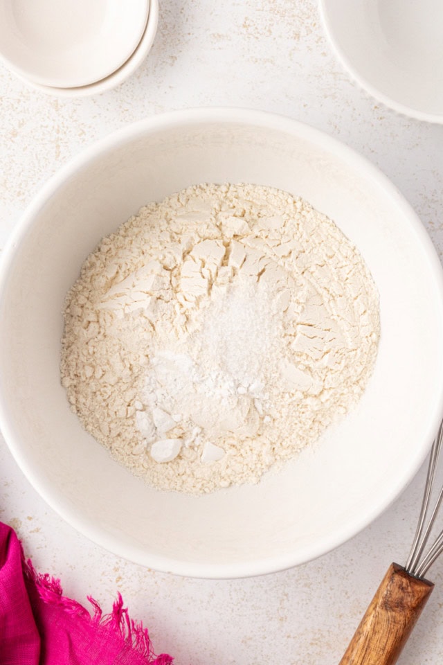 overhead view of flour, baking powder, and salt in a white mixing bowl