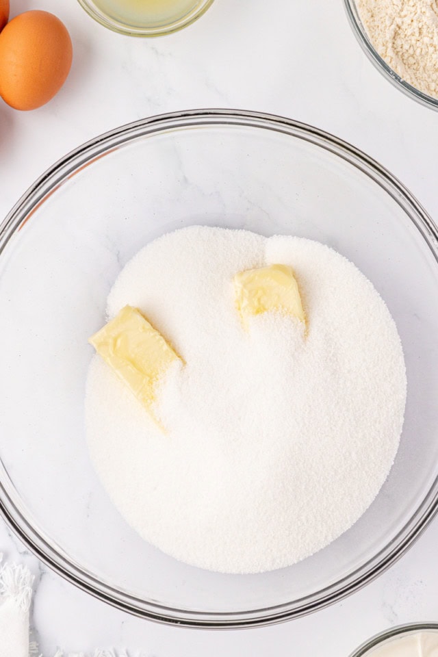 overhead view of butter and sugar in a glass mixing bowl