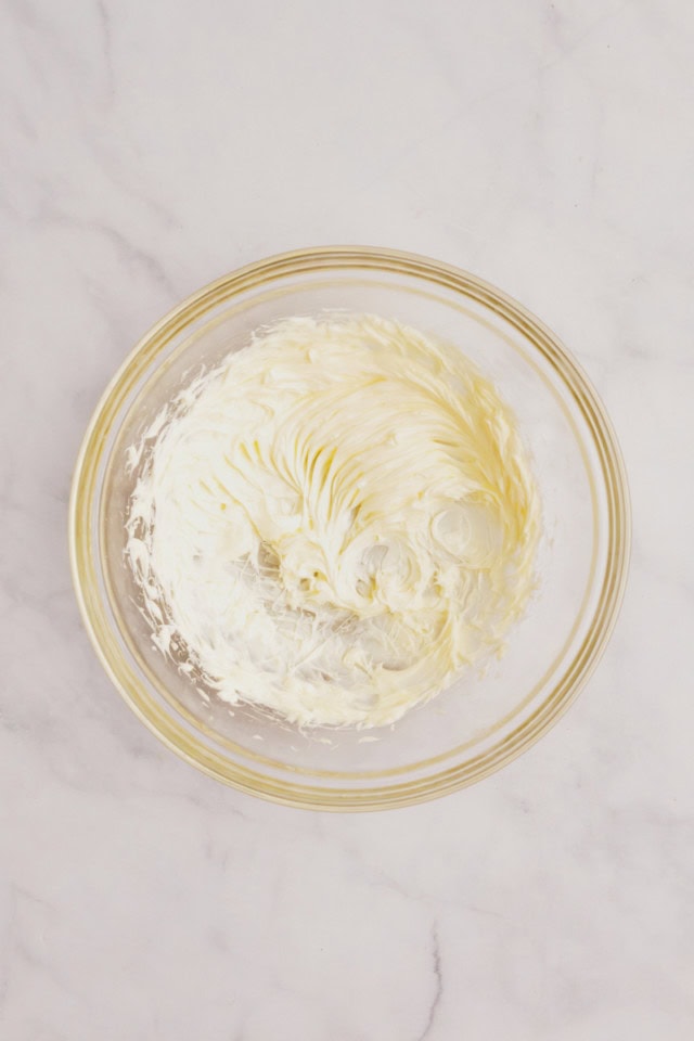 overhead view of creamed butter in a glass mixing bowl