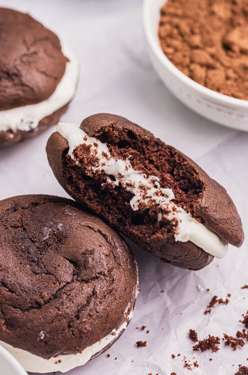 a whoopie pie with a bite missing leaned against another whoopie pie