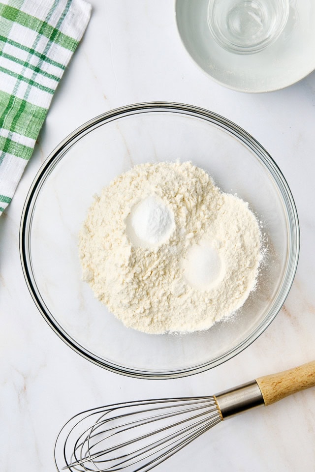 overhead view of flour, baking soda, and salt in a glass mixing bowl