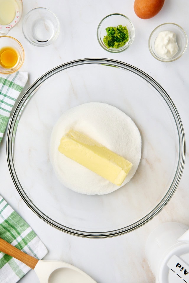 overhead view of butter and sugar in a glass mixing bowl