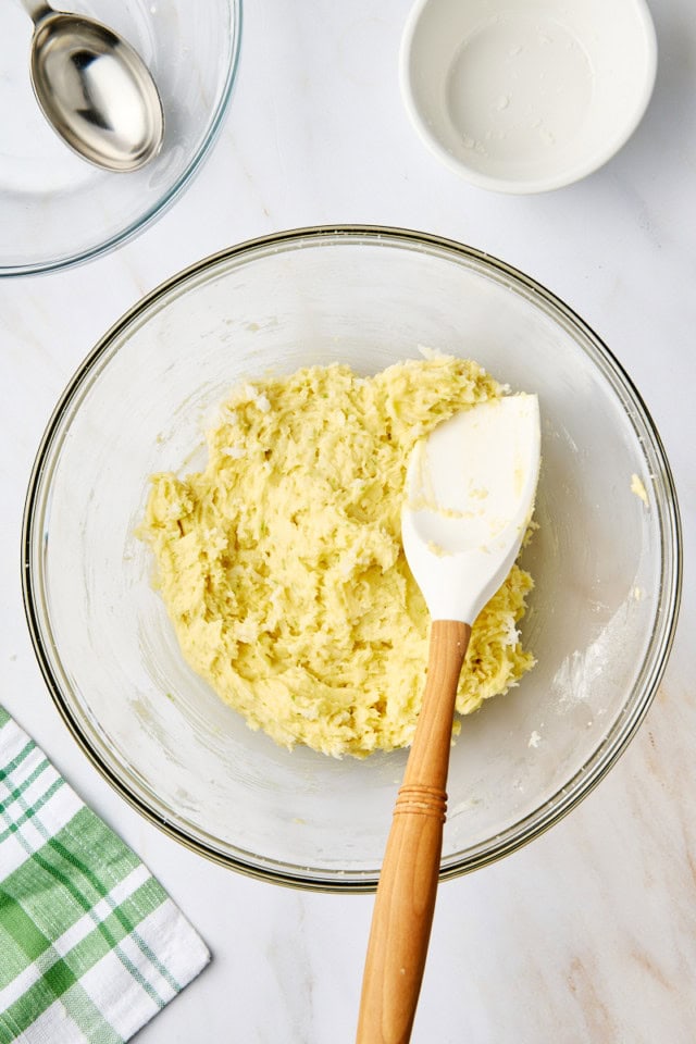 overhead view of mixed coconut lime cookie dough in a glass mixing bowl