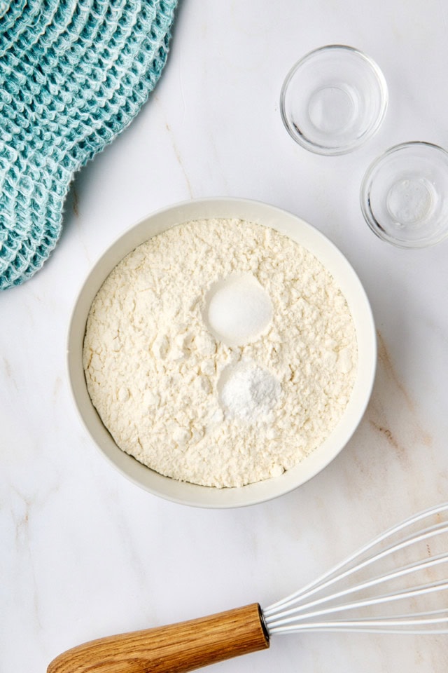 overhead view of flour, baking powder, and salt in a white mixing bowl