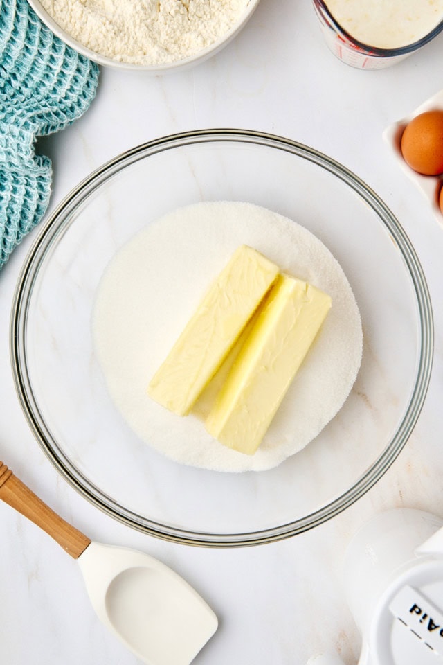 overhead view of butter and sugar in a glass mixing bowl