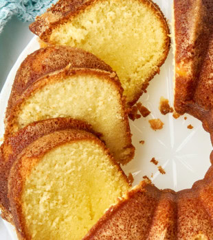 overhead view of partially sliced five flavor pound cake on a white cake plate
