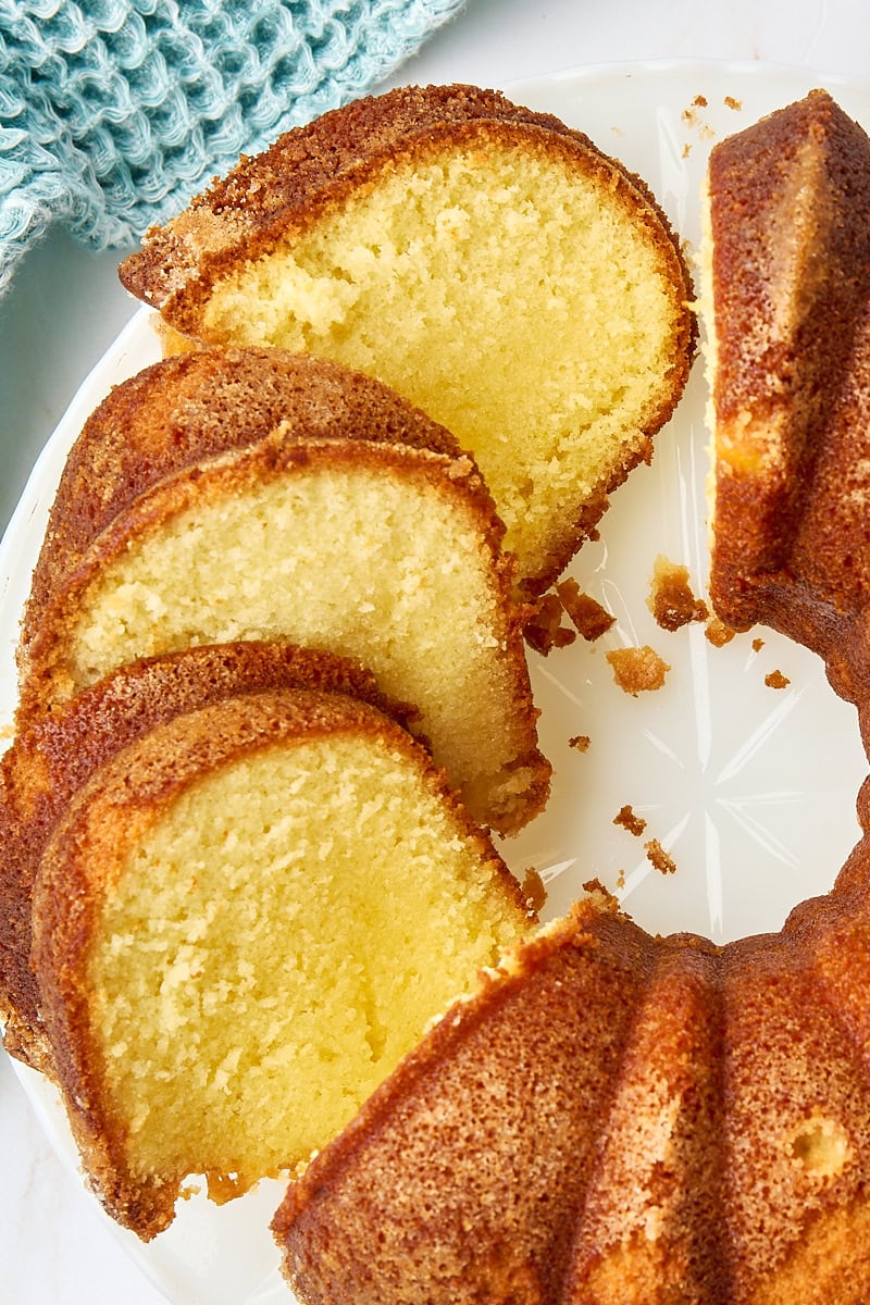 overhead view of partially sliced five flavor pound cake on a white cake plate