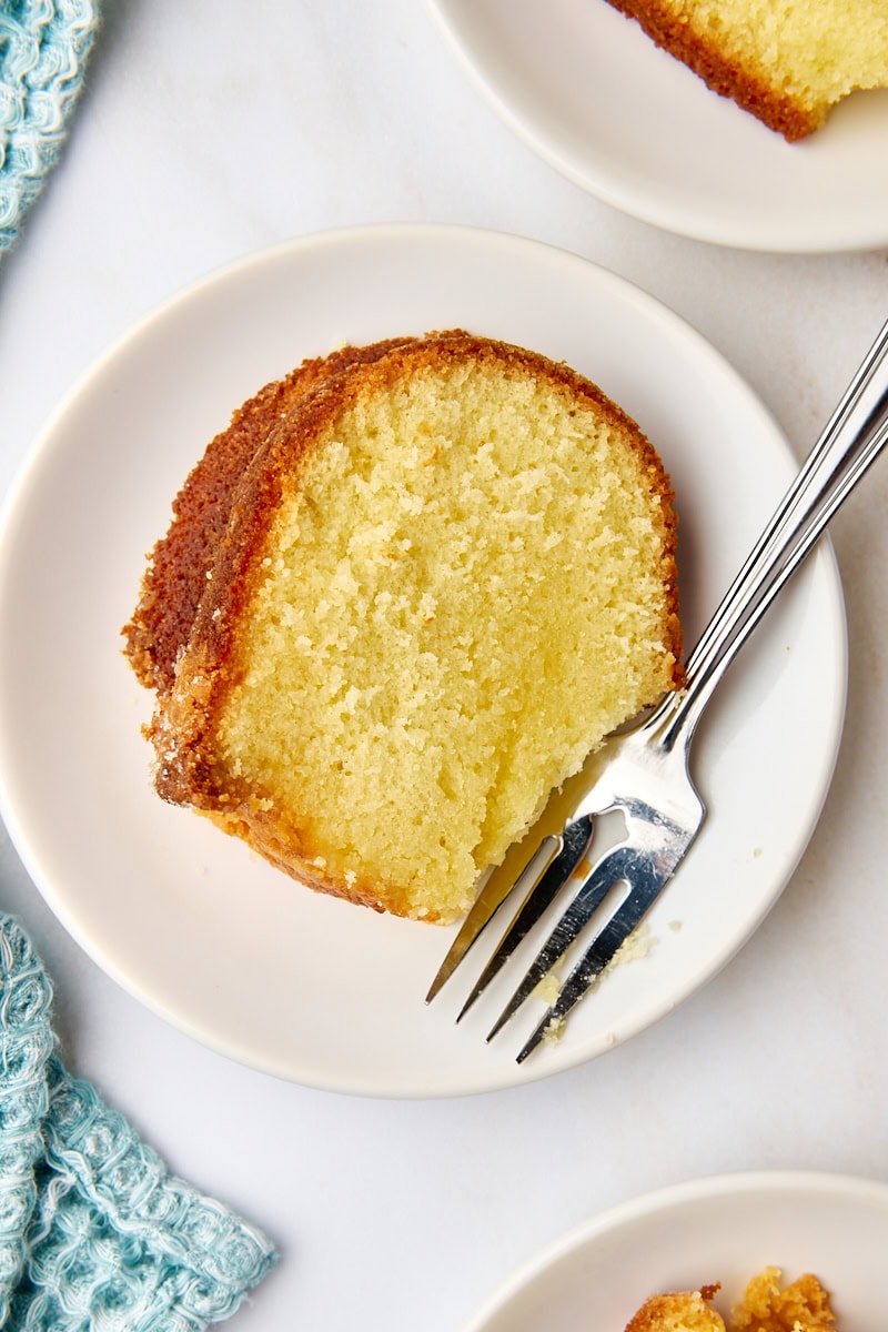 overhead view of a slice of five flavor pound cake on a white plate with a fork