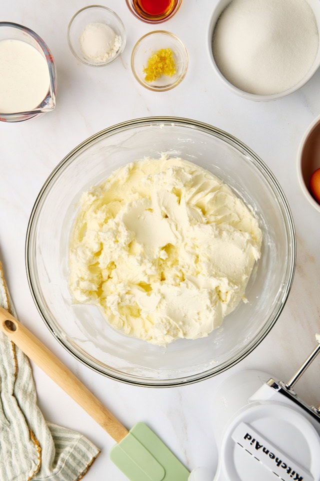 overhead view of beaten cream cheese in a glass mixing bowl