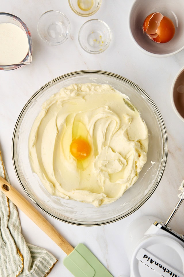 overhead view of egg added to cheesecakemixture