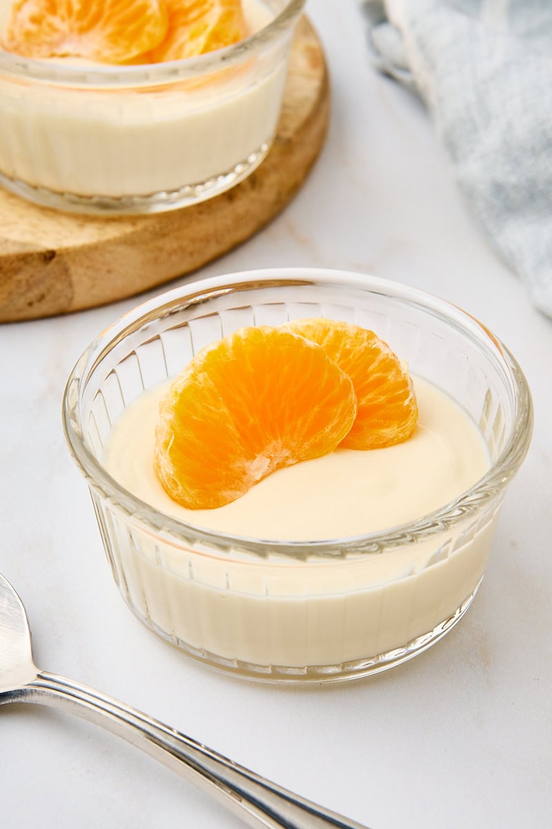 ricotta mousse topped with two mandarin slices and served in a clear glass ramekin