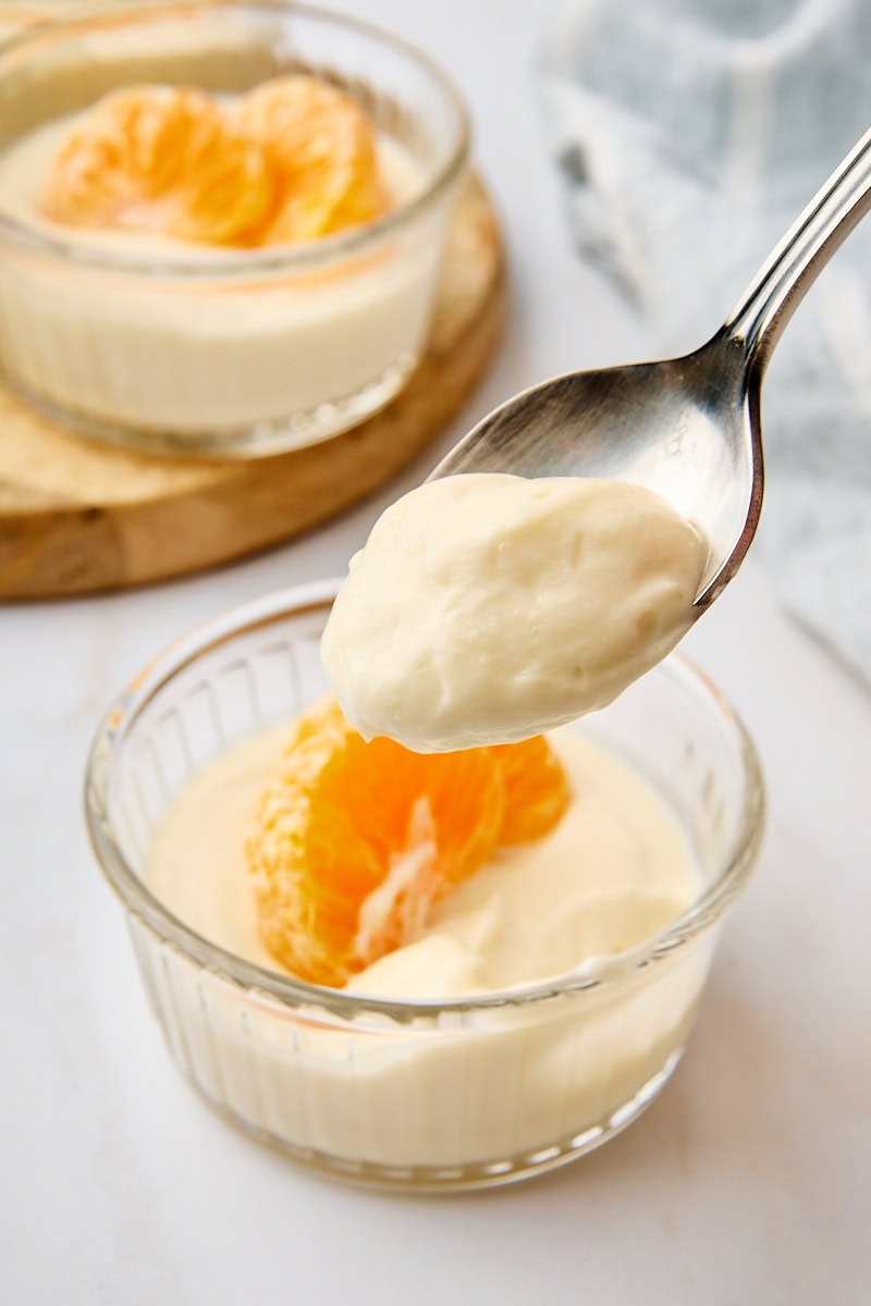 a bite of ricotta mousse on a spoon with remaining mousse in the background