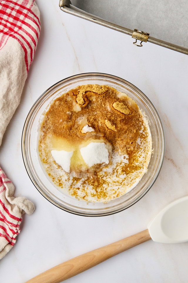 overhead view of graham cracker crumbs, sugar, and melted butter in a bowl