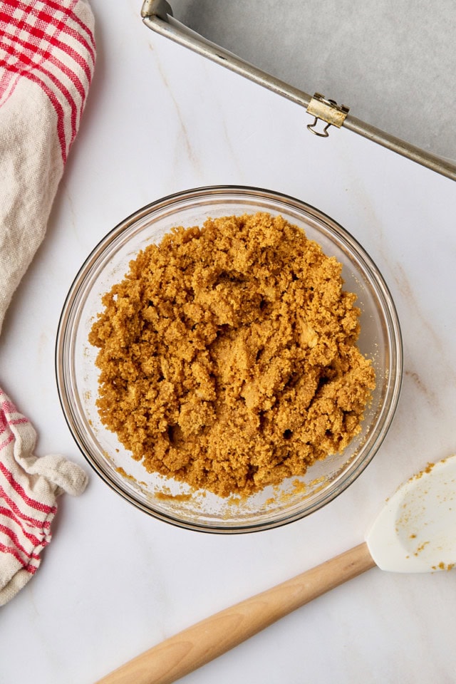 overhead view of graham cracker crust mixture in a mixing bowl