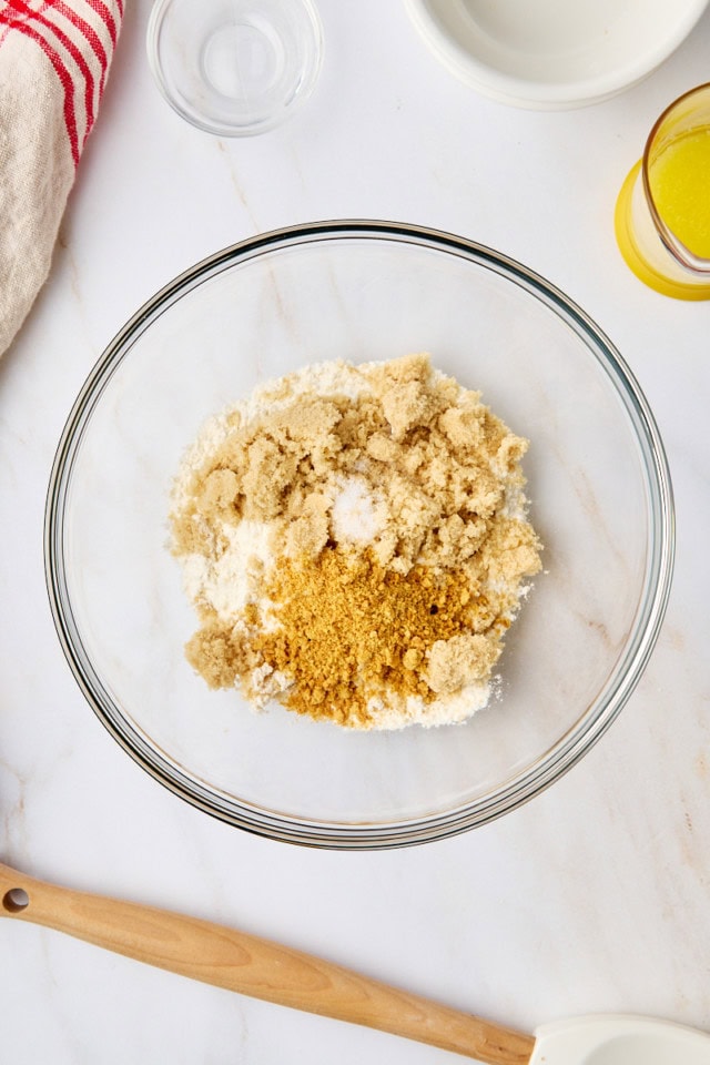 overhead view of flour, brown sugar, graham cracker crumbs, and salt in a mixing bowl