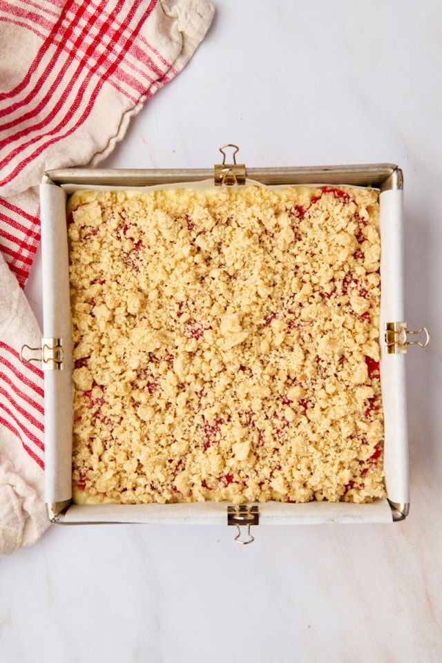 overhead view of assembled strawberry cheesecake bars in a square pan ready to go into the oven
