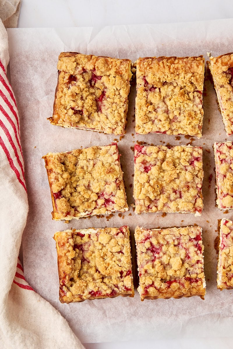 overhead view of sliced strawberry cheesecake bars on parchment paper