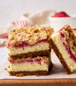two stacked strawberry cheesecake bars with another bar leaned against them