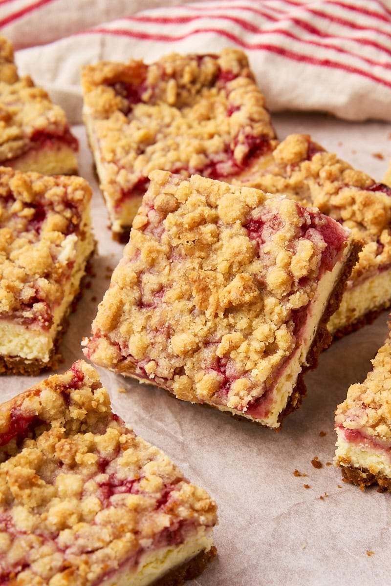 strawberry cheesecake bars scattered on parchment paper