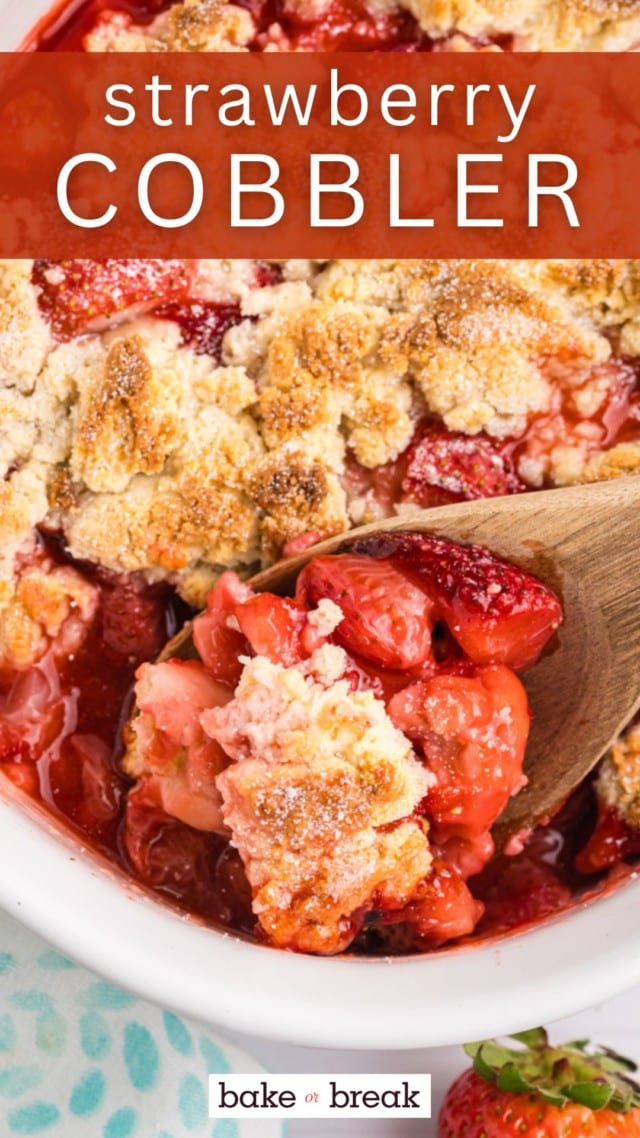 a spoonful of strawberry cobbler on a wooden spoon with more cobbler in the baking dish in the background; text overlay "strawberry cobbler"