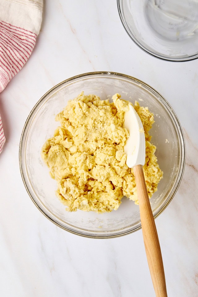 overhead view of biscuit dough in a glass mixing bowl
