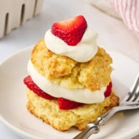 a strawberry shortcake and a fork on a white plate