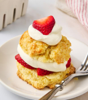 a strawberry shortcake and a fork on a white plate