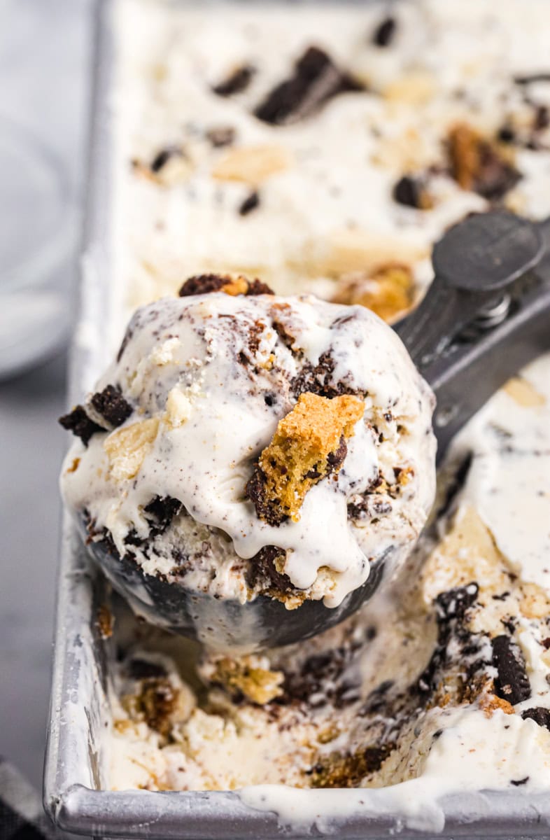 a scoop of all the cookies ice cream resting on top of the remaining ice cream
