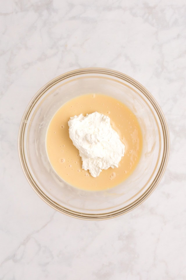 overhead view of a bit of whipped cream added to condensed milk mixture for all the cookies ice cream
