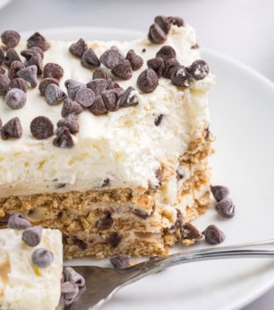 close-up view of a slice of cannoli icebox cake on a white plate with a bite on a fork