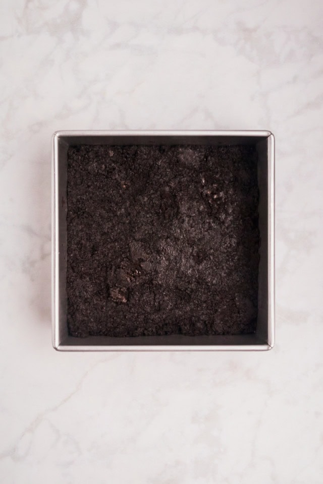 overhead view of Oreo crust pressed into the bottom of a square baking pan