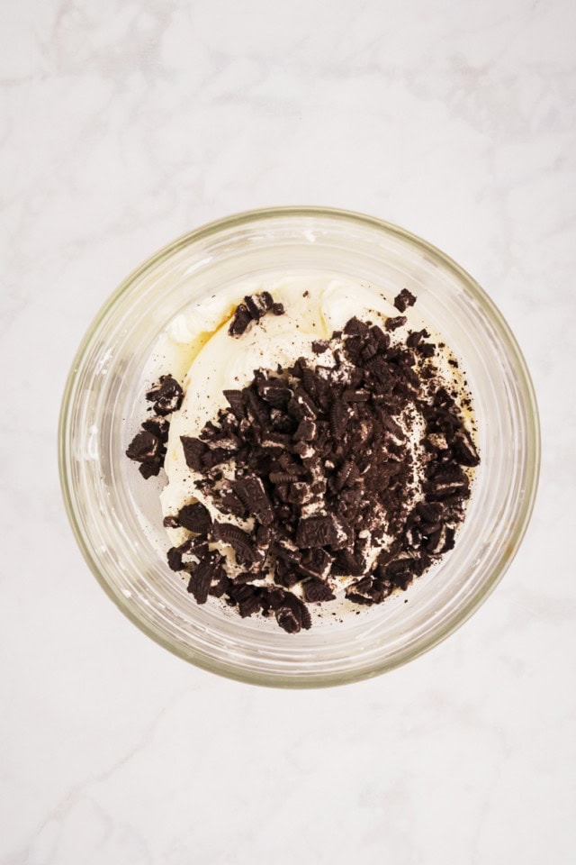 overhead view of Oreo cookie pieces added to no-bake cheesecake filling