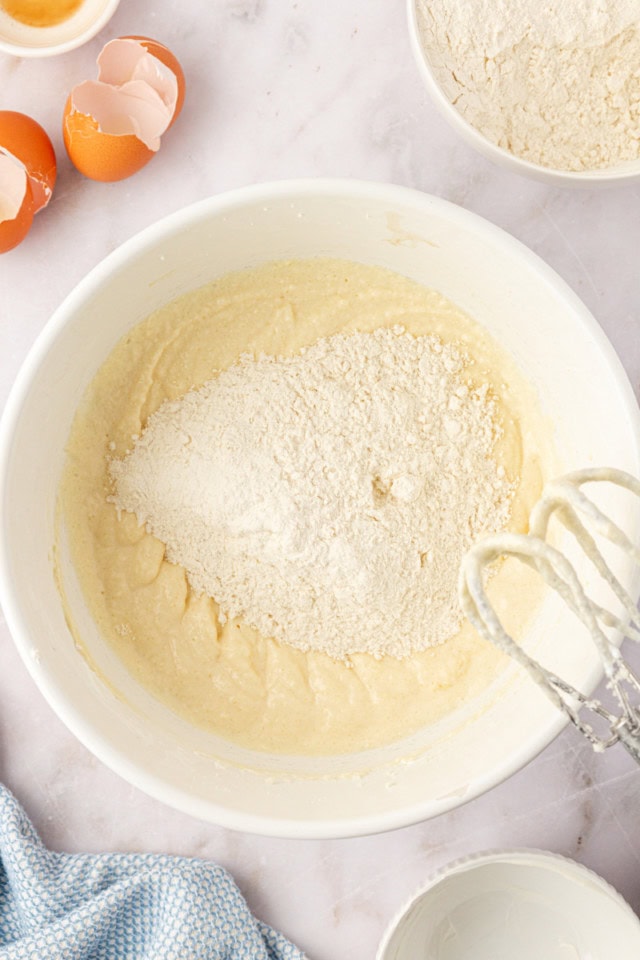 overhead view of dry ingredients added to wet ingredients for peach coffee cake