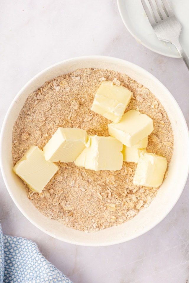 overhead view of cubed butter added to topping mixture