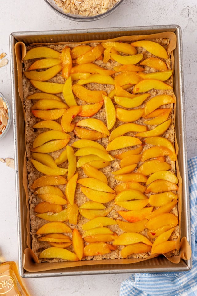 sliced peaches arranged on top of par-baked shortbread crust